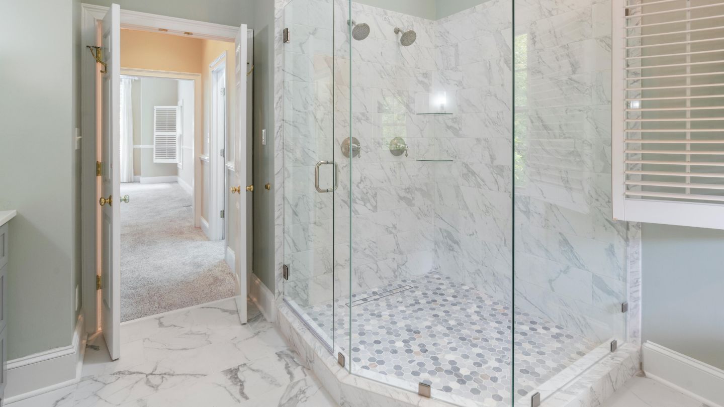 Frameless glass shower remodel with marble tile in modern bathroom renovation
