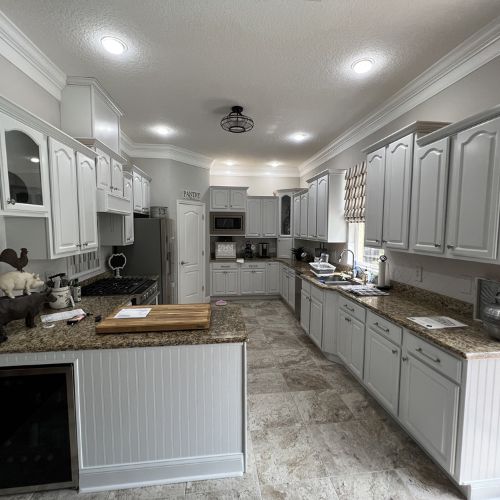 Kitchen cabinet painting in Tampa featuring modern white cabinets, granite countertops, and updated kitchen flooring